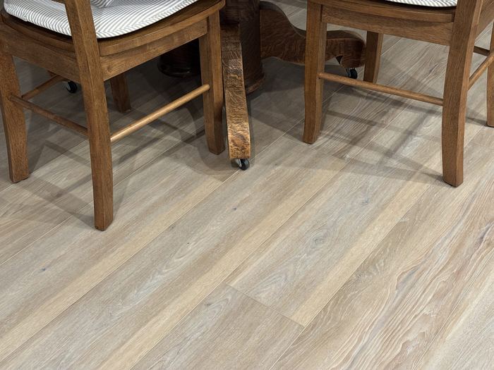LVP flooring beneath a dining table and wooden chairs